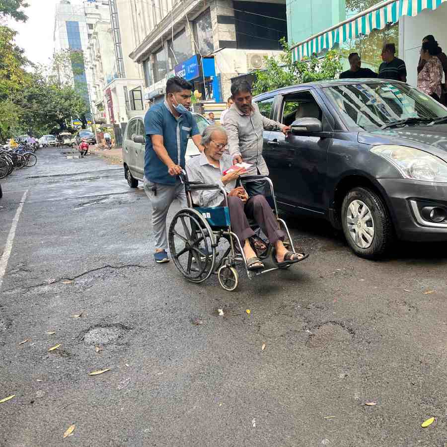 মণিপাল হাসপাতালের সামনে অ্যাম্বুল্যান্স থেকে নেমে হুইল চেয়ারে রোগী।