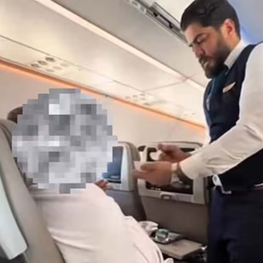 Airlines crewmember gently feeding an elderly passenger