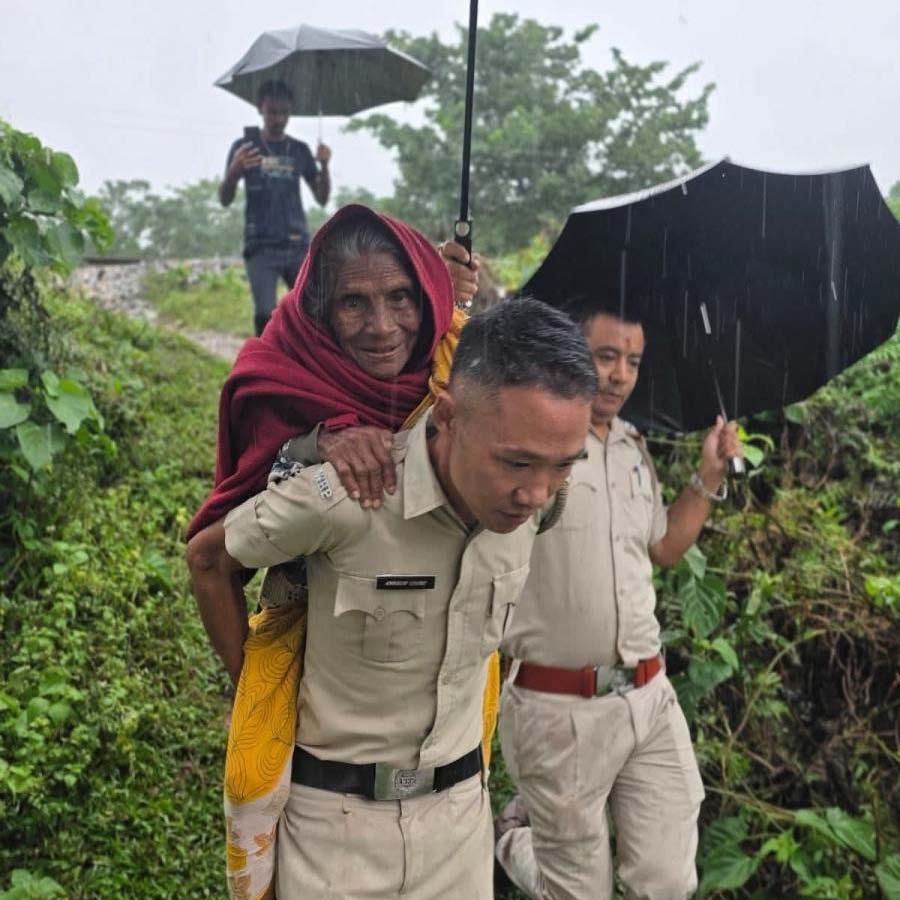 বৃদ্ধাকে পিঠে চাপিয়ে বিন্নাগুড়িতে ত্রাণ শিবিরে নিয়ে যাচ্ছে পুলিশ।