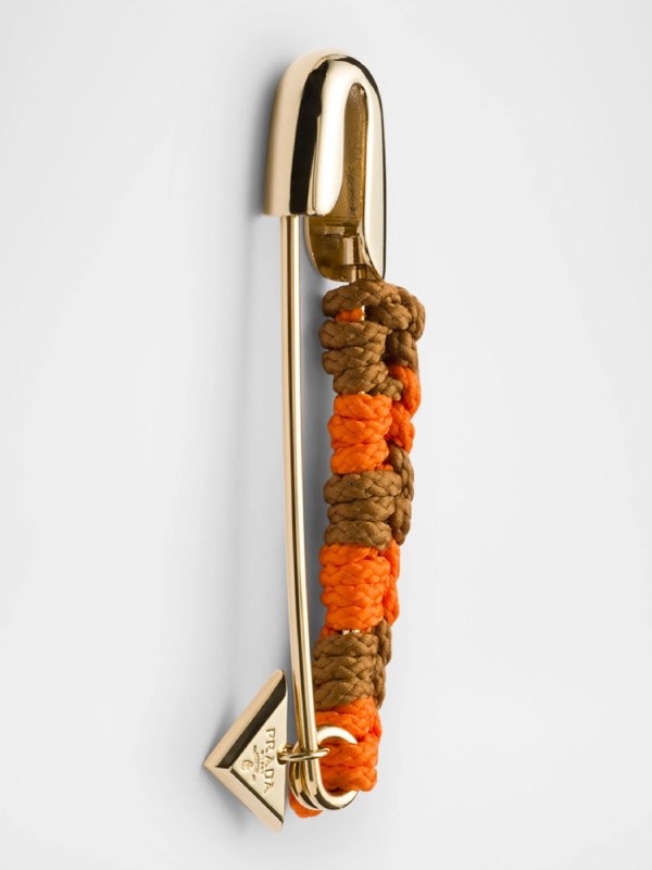  দু’রঙের উল সোজা-উল্টো করে এক কাঁটা বোনা। সঙ্গে প্রাডার লোগো দেওয়া তিনকোনা পিতলের টুকরো ঝুলিয়ে দেওয়া হয়েছে।