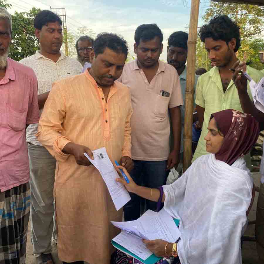 ভোটার তালিকা সংশোধনের ফর্ম বিলি করছেন ডোমকলের এক বিএলও।