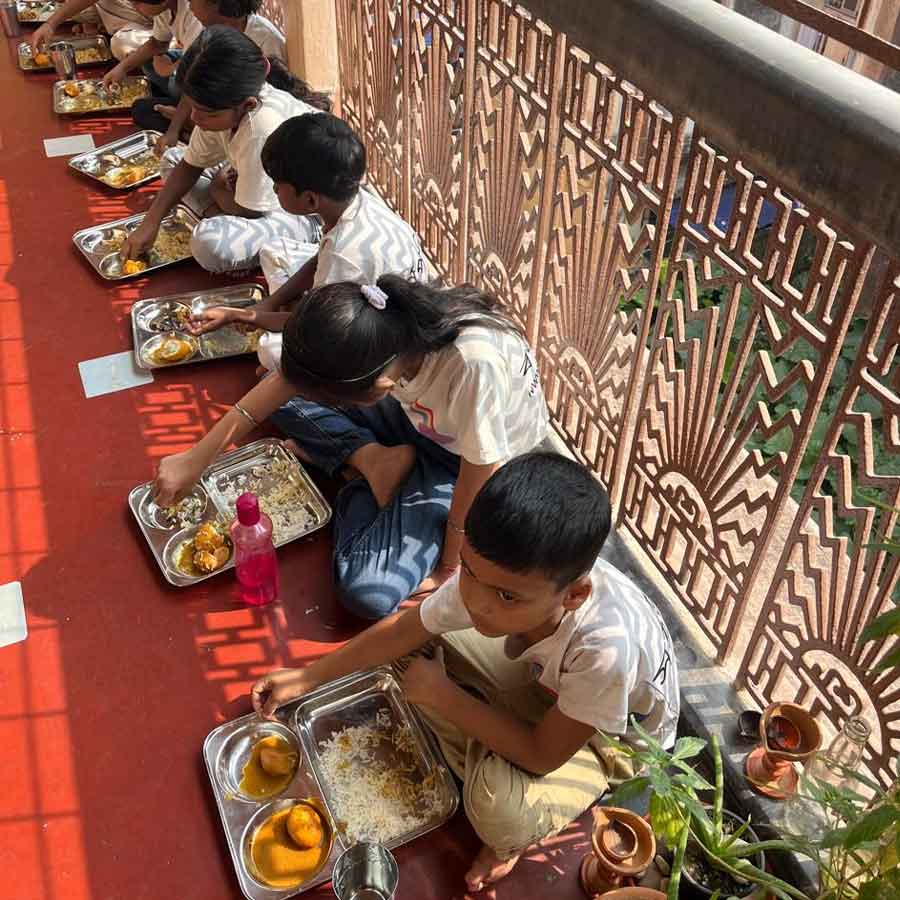 দালানে বসে দুপুরের খাবার খাচ্ছে।