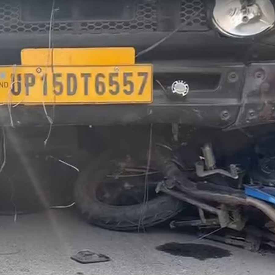 ট্রাকের নীচে চাপা পড়ে রয়েছে বাইক। ছবি: সংগৃহীত।