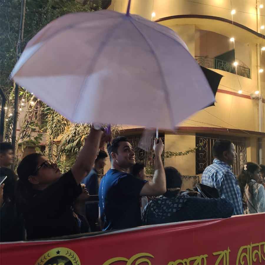 দমদম তরুণ দলের ঠাকুর দেখতে বৃষ্টিতে মাথায় ছাতা দিয়ে অপেক্ষা। 