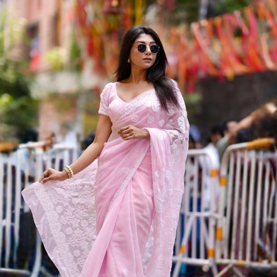 দেবলীনা হালকা গোলাপি অরগাঞ্জা শাড়ি, হাতে বালা, চোখে সানগ্লাসে ধরা দিলেন এ দিন।