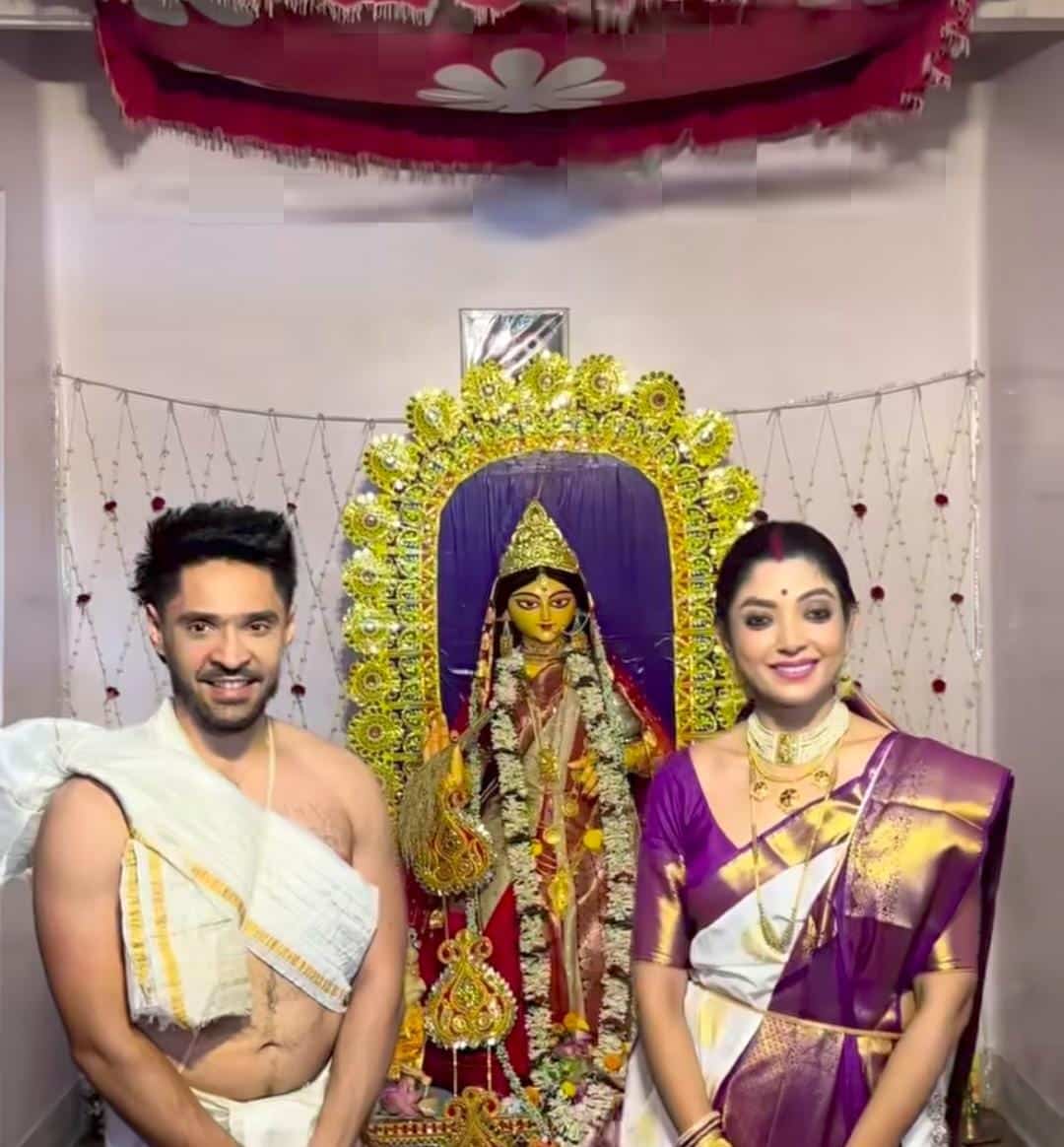 বাড়ির পুজোয় এ দিন গৌরবকে সাদা ধুতিতে দেখা যায়। অন্য দিকে দেবলীনা পড়েছিলেন সাদা বেগুনি পাড় শাড়ি। খোঁপায় এ দিন তাঁকে জুঁইয়ের মালাও লাগাতে দেখা যায়। 