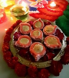 মিষ্টির আকার দেওয়া: ডো হালকা গরম থাকতে হাতে ঘি মাখুন। তার থেকে ছোট ছোট অংশ তুলে নিন। এ বার হাতে সেগুলিকে গোল করে গড়ে নিন। এগুলিই হবে প্রদীপের মূল অংশ।