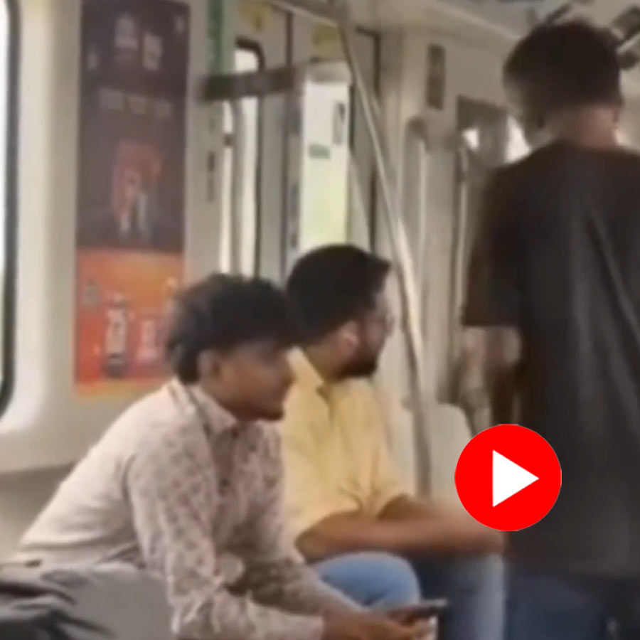 man asking for money from the seated passengers in metro