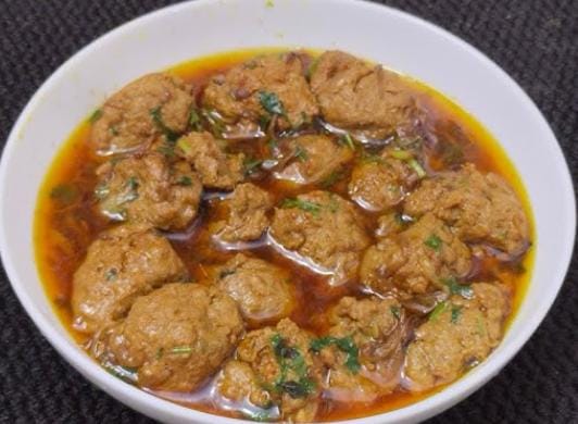 হালকা নেড়ে ঢেলে দিন সেদ্ধ চিংড়ি বড়াগুলি। দিয়ে দিন সেই জলটাও। এবার ভাল করে ঝোল ফুটিয়ে নিন। 