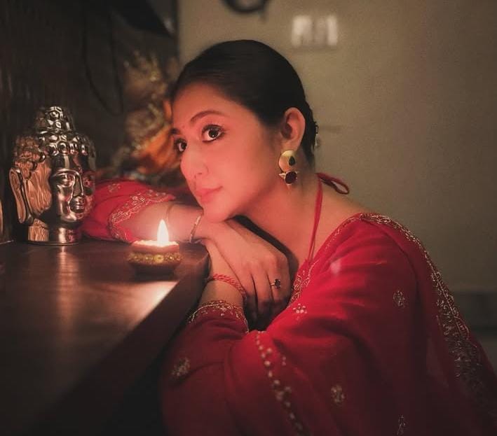 পরনে লাল পোশাক। আলো আঁধারিতে মোহময়ী স্বীকৃতি মজুমদার। (এই প্রতিবেদনটি ‘আনন্দ উৎসব’ ফিচারের একটি অংশ)।