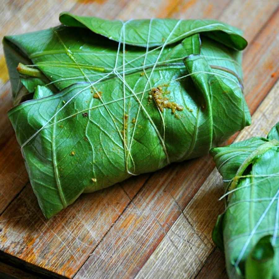 তার পর সেই কলাপাতাগুলোয় পরিমাণ মতো এই মিশ্রণ দিয়ে দিন। সঙ্গে দিন এক ফোঁটা সর্ষের তেল, একটা চেরা কাঁচা লঙ্কা এবং এক টুকরো নারকেল। এ বার ভাল করে পেঁচিয়ে দড়ি দিয়ে বেঁধে নিন। 