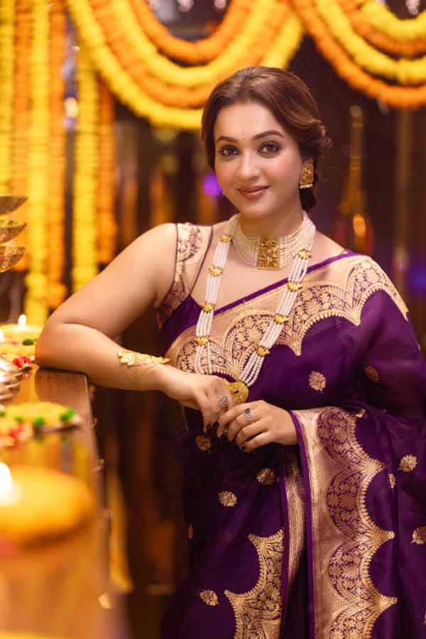 আলোর উৎসবে অভিনেত্রী কৌশানি মুখোপাধ্যায়ের সাজ ছিল বেশ জমকালো। গাঢ় বেগনিরঙা চওড়া সোনালি পাড় কাতান শাড়ি পরেছিলেন তিনি। চুলে খোঁপা, গলায় ছিল মুক্তো এবং সোনার গয়না, কানে দুল, হাতে মান্তাসা।