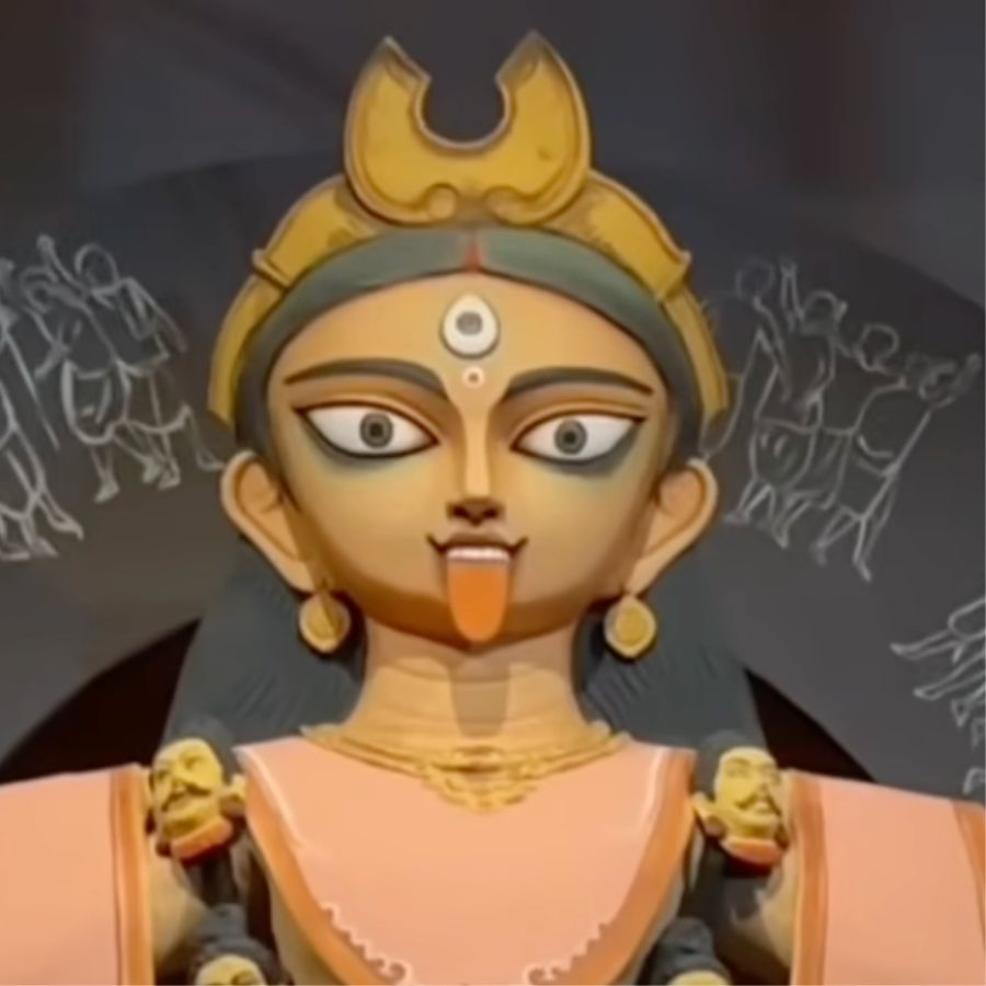 কালী প্রতিমার সজ্জাতেও রয়েছে বিশেষ বার্তা। এখানে মাতৃপ্রতিমা সাদা শাড়ি ও কমলা রঙের উত্তরীয় পরিহিতা। 