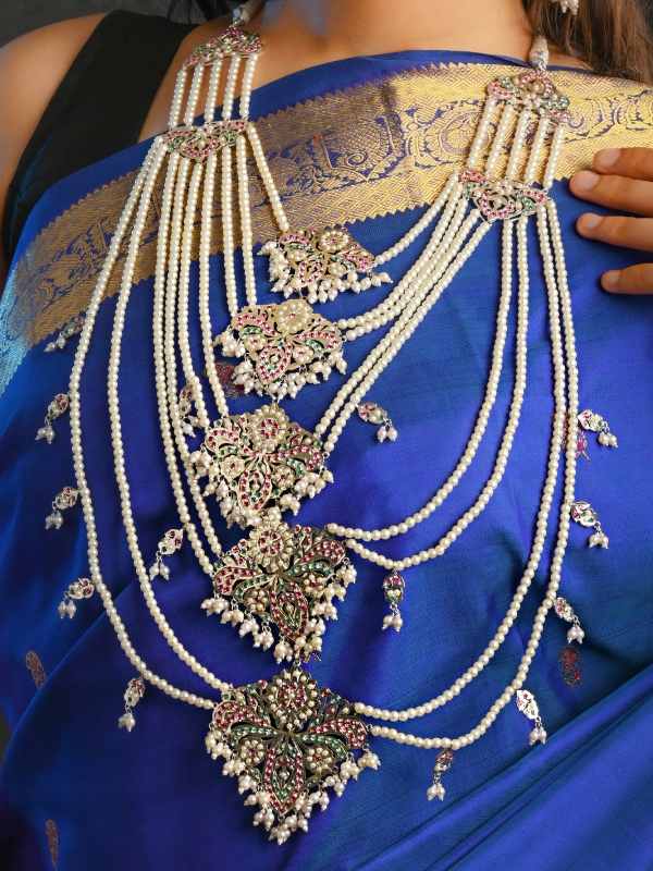 রুপোর পাশা আর মুক্তোর হালি দিয়ে তৈরি ন’লহরী হার।  এক রঙা বেনারসির উপর এই একটি হার থাকলে, অন্য দিকে নজর পড়বে না। 