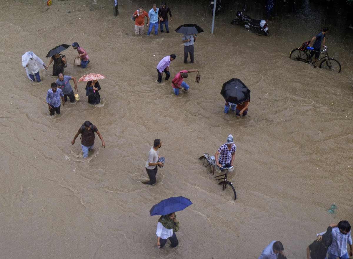 গুরুগ্রামে বৃষ্টি মাথায় নিয়ে জল পেরিয়ে গন্তব্যে পৌঁছোনোর চেষ্টায় স্থানীয়েরা।