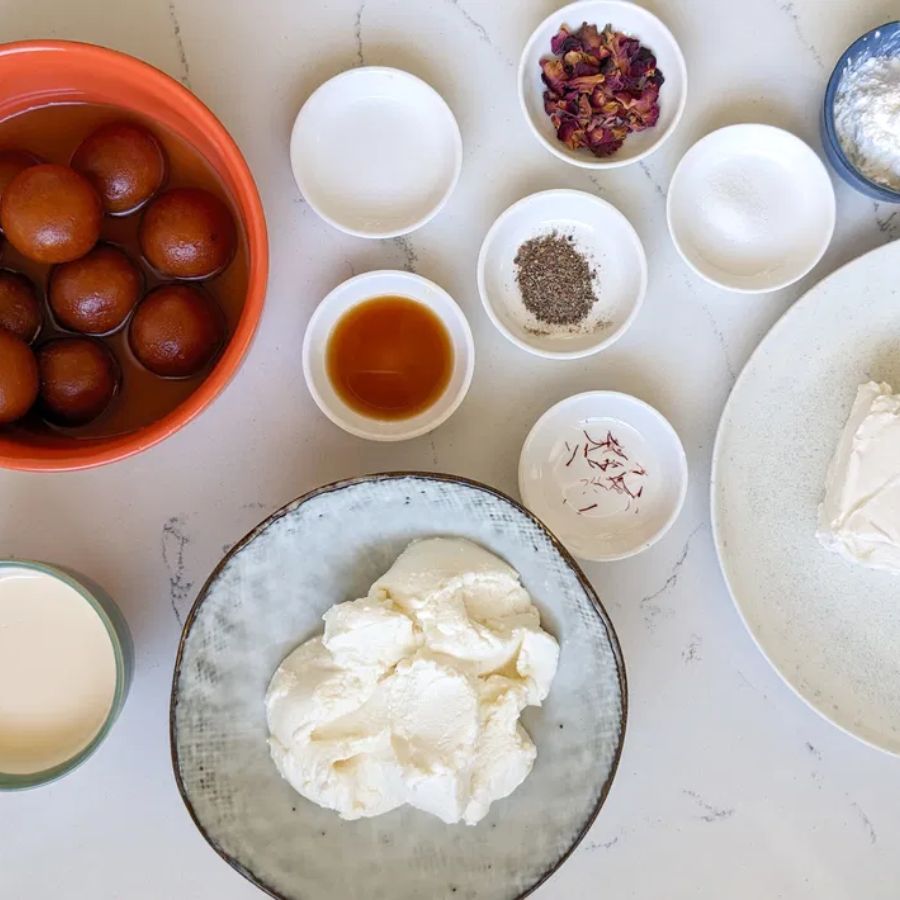 ৩. তৈরি করা কিন্তু মোটেই কঠিন নয়। বাজারে সহজেই পাওয়া যায় গুলাব জামুন, আর বাকি উপাদান—ক্রিম চিজ়, বিস্কুট, মাখন, ফ্রেশ ক্রিম, চিনি— সবই ঘরে মজুত থাকে সাধারণত।