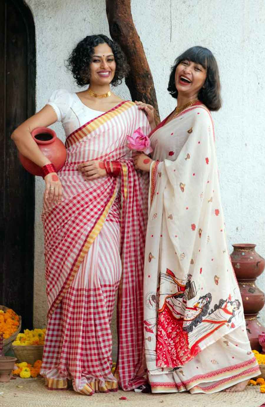 পুজো মানে চৌকাঠে আল্পনা। ঠাকুরদালানের চাতালে ঝুড়িতে ১০৮ পদ্ম। রেডিয়োতে ‘মহিষাসুরমর্দ্দিণী’। দূরাগত শাঁখের আওয়াজ। ঢাকের বাদ্যি। বাতাসে ধুনোর গন্ধ। এই সব কিছু ১২ হাতের ক্যানভাসে বন্দি করেছেন ‘সুতা’র সু-সুজাতা বিশ্বাস এবং তা-তানিয়া বিশ্বাস। বাংলার পুজোর চিরকালীন শুভ রং— সাদা-লাল। সেই রং মিলন্তিতেই দুধ সাদা মল কটনের উপর লাল আর ম্যাট সোনালি ব্লক প্রিন্ট। শাড়িটি অনায়াসে ষষ্ঠীর বোধন বা অষ্টমীর অঞ্জলির সাজ হতে পারে। পাশের ডোলা সিল্কে গামছা চেকের শাড়িটি হতে পারে  দশমীর ঠাকুর বরণের জন্যও আদর্শ।