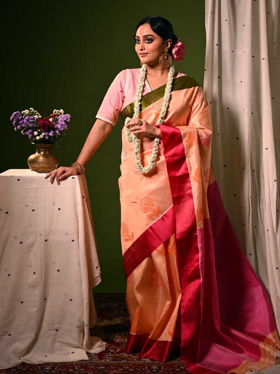 বাংলার পুজো মানে যতটা ফ্যাশন, ততটাই খাওয়াদাওয়া। আর বাঙালির খাওয়া মানে শেষপাতে মাটির ভাঁড়ে লালচে মিষ্টিদইও জরুরি। এ বার ভাবুন তো, সেই প্রিয় মিষ্টির রং যদি পোশাকে ধরা যায়, কেমন হবে? পরমা ধরেছে। তার পুজোর সম্ভারের রয়েছে মিষ্টিদই-মারিগোল্ড গরদ শাড়ি। মিষ্টিদই তো বোঝা গেল, কিন্তু মারিগোল্ড! গাঁদাকে ফ্যাশনে আনার চেষ্টা কমই দেখা গিয়েছে। পরমা তার মিষ্টিদই রঙা গঙ্গা-যমুনা পাড় গরদ শাড়িতে রেখেছে গাঁদা ফুলের মোটিফ। এ শাড়ি অষ্টমীর সকাল বা নবমীর রাত, যে কোনও সময়েই নজর কাড়বে।