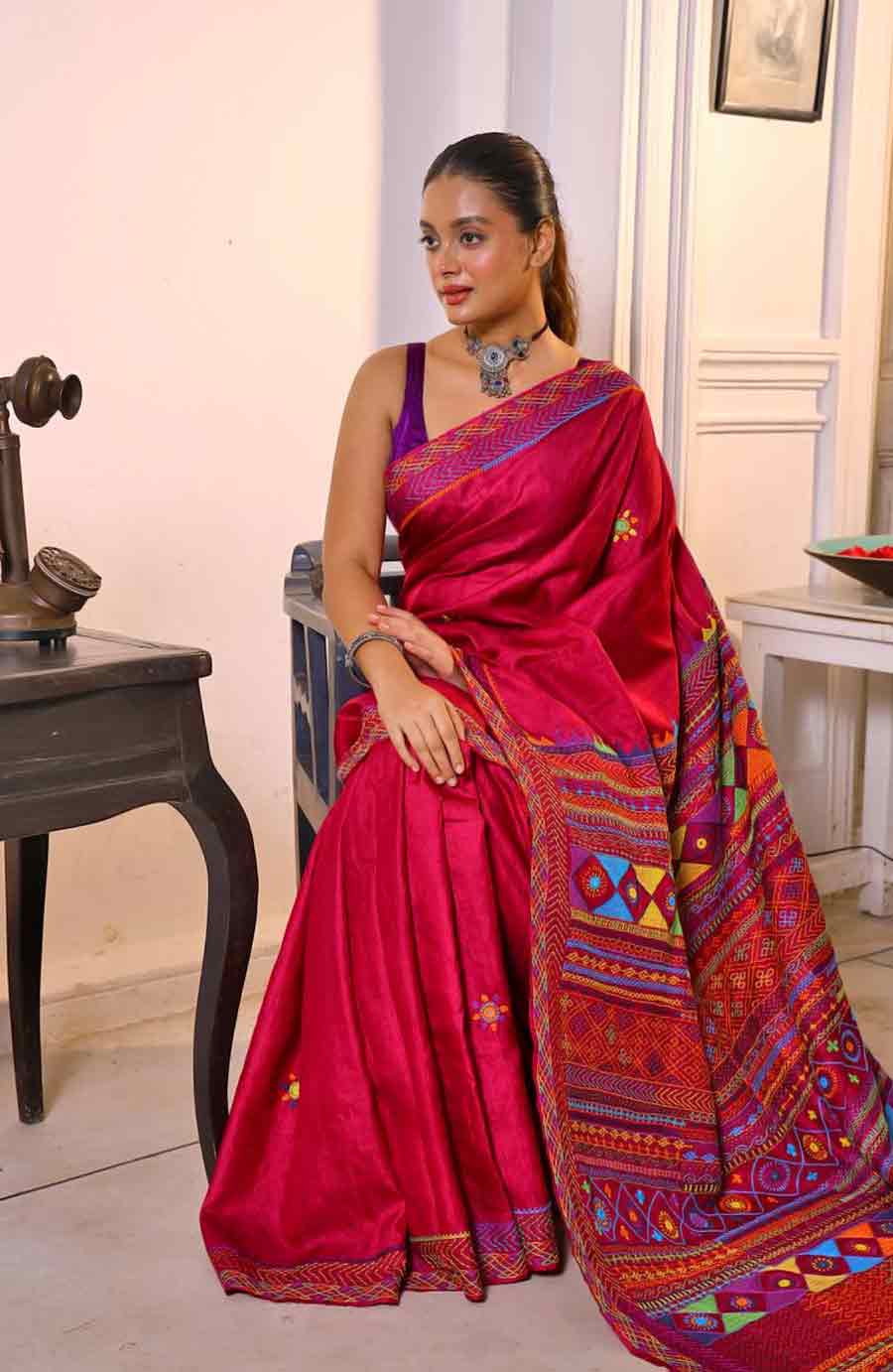 গাঢ় রানি গোলাপি রঙের হাতে বোনা গাছি তসর। সে কাপড়ের রং, তার ঔজ্জ্বল্য এমনিই ভিড়ের মধ্যে আলাদা করে নজরে পড়ে। তার উপরে এই শাড়িতে গুজরাতের রঙিন সুতোর লাম্বানি কাজ করিয়েছে এথনিক বুটিক। লম্বানি স্টিচের কাজ এ বছর বাজারে গেলেই দেখতে পাওয়া যাচ্ছে। বাংলার কাঁথা স্টিচের মতোই রঙিন সুতোর এই নকশা কাজ বাঙালি শৌখিনীদের মনে ধরেছে। মানুষ কিনছেনও বেশি। এথনিক বুটিকের এই শাড়ি সপ্তমীর সন্ধ্যার জমকালো সাজ হতে পারে।