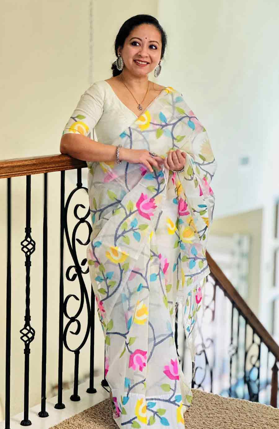 পুজোর সাদা শাড়িতে কি শুধু লালেরই নকশা থাকতে হবে? বাঁশি বুটিক অন্তত তা মনে করে না। তাদের পুজোর সম্ভারে সকালে পরার যে সাদা শাড়িটি রাখা হয়েছে, তার ফিনফিনে সিল্ক মসলিনের জমি জুড়ে রঙিন ফুলের নকশা। লতানো কালচে সুতোর মৃণালে জড়িয়ে রয়েছে গোলাপি-হলুদ পদ্ম।