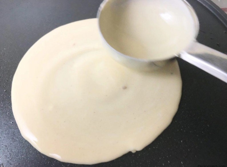 পাটিসাপটা তৈরির চূড়ান্ত ধাপ: একটি নন-স্টিক তাওয়া বা ফ্রাইং প্যান গরম করুন। তাতে সামান্য তেল ব্রাশ করে নিন। একটি চামচে করে ব্যাটার নিয়ে তাওয়ার মাঝখানে ঢেলে গোলাকারে ছড়িয়ে দিন। আলতো হাতে একটি পাতলা রুটির মতো স্তর তৈরি করুন।