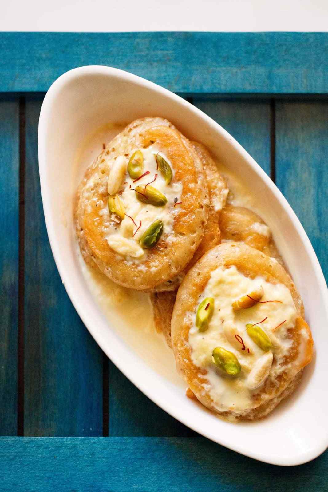 চিনির সিরা তৈরি: একটি পাত্রে ২ কাপ চিনি এবং ১.৫ কাপ জল মিশিয়ে গ্যাস ওভেনে বসান। এতে গোটা ছোট এলাচ দিয়ে দিন। মাঝারি আঁচে নাড়তে থাকুন যত ক্ষণ না চিনি গলে যায়। সিরাটি খুব ঘন করার প্রয়োজন নেই, একটু চিটচিটে হলেই হবে।