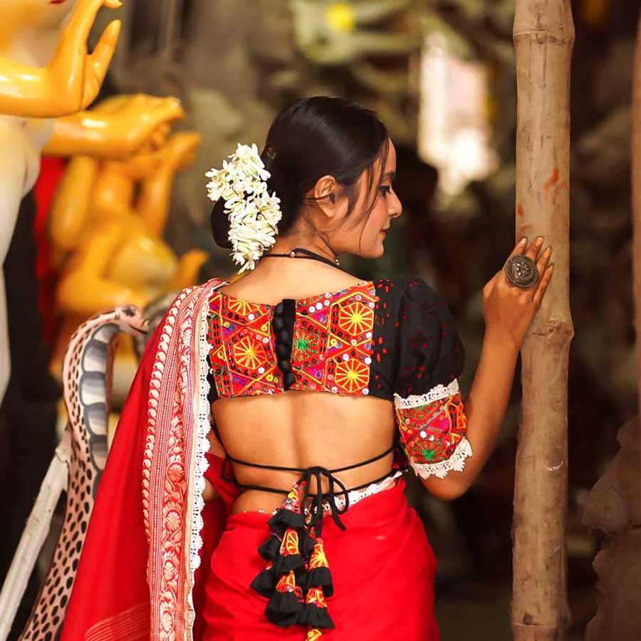 বয়স ১৬ হোক কিংবা ৬০, দুর্গাপুজোর ক’দিন শাড়ি পরার শখ কমবেশি সব মহিলারই হয়। শাড়ির আবেদন এক এক মেয়ের কাছে এক এক রকম। কেউ পুজোতে সাবেকি কায়দার শাড়ি পরতে চান, কেউ আবার শাড়ি পরেই পুজোর ভিড়ে উষ্ণতা ছড়াতে চান। তবে কেবল শাড়ি পরলেই তো হল না, শাড়ির সঙ্গে চাই কায়দার ব্লাউজ়ও। শাড়ির রং মিলিয়ে ব্লাউজ় পরার চল পুরনো হয়েছে, এখন কনট্রাস্ট ব্লাউজ়ের যুগ। পুজো আসতে আর খুব বেশি দিন বাকি নেই, তাই দর্জির কাছে কায়দায় ব্লাউজ় বানানোর আর্জি নিয়ে গেলেও কোনও লাভ হচ্ছে না। অফিস, সংসার সামলিয়ে অনেকে এখনও ঠিক করে উঠতে পারেননি, সপ্তমীর সকালে, অষ্টমীর অঞ্জলিতে, নবমীর রাতে অথবা দশমীর বরণে ঠিক কোন ধরনের ব্লাউজ় পরবেন। শেষ মুহূর্তে ব্লাউজ় বাছাই করার আগে জেনে নিন কোন কায়দার ব্লাউজ় এ বছর ফ্যাশনে ‘ইন’। আনন্দবাজার ডট কমে পুজোর জন্য শেষ মুহূর্তের ‘সাজেশন’ সাজিয়ে দিলেন খ্যাতনামী সব বুটিকের পোশাকশিল্পীরা।