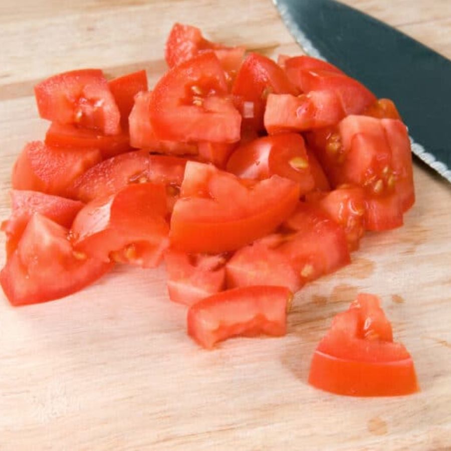 এ বার কড়াইয়ে যোগ করুন কেটে রাখা টমেটো। দিয়ে দিন গোটা কাঁচা লঙ্কাগুলিও। এ বার আবারও ঢিমে আঁচে ভাল করে কষতে থাকুন যত ক্ষণ না তেল ছাড়ছে রান্না থেকে। 