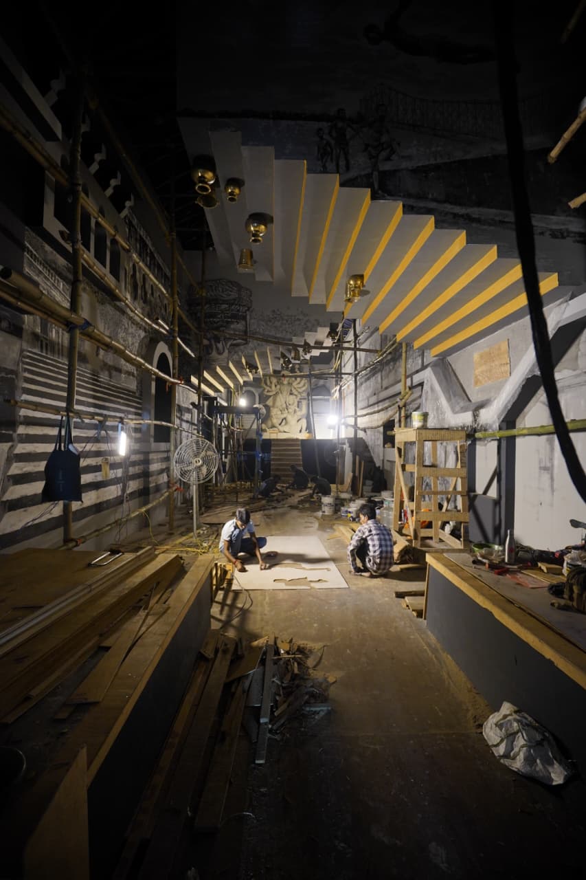 হাতিবাগানের মণ্ডপের জন্য থমাস নিজের হাতে এঁকেছেন ২২ ফুট বাই ৪ ফুটের এক বিশাল ক্যানভাস। ২০,০০০ সোনালি সুতোয় বোনা এই ছবিতে যেন কলকাতার গঙ্গার পাড়ের এক টুকরো জীবনকে তুলে ধরা হয়েছে। ( এই প্রতিবেদনটি ‘আনন্দ উৎসব’ ফিচারের একটি অংশ। ) 