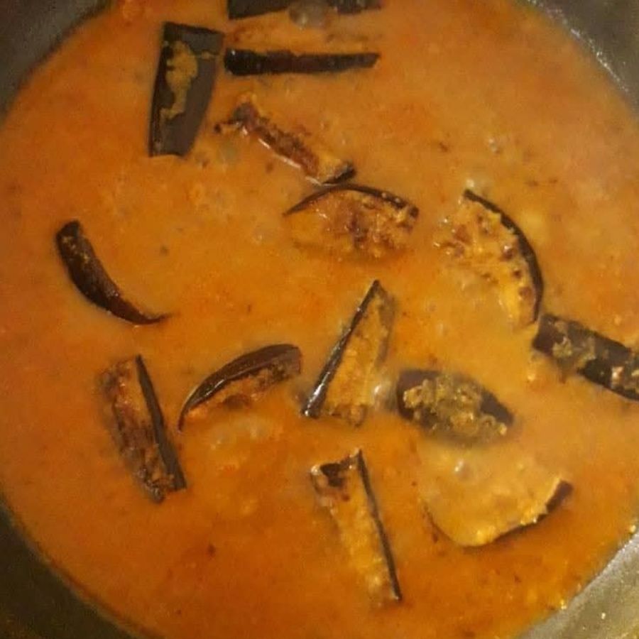 ৭.  গ্রেভি ঘন হয়ে এলে ভাজা বেগুনগুলি আলতো করে দিয়ে দিন। সাবধানে নাড়বেন যাতে বেগুন ভেঙে না যায়।