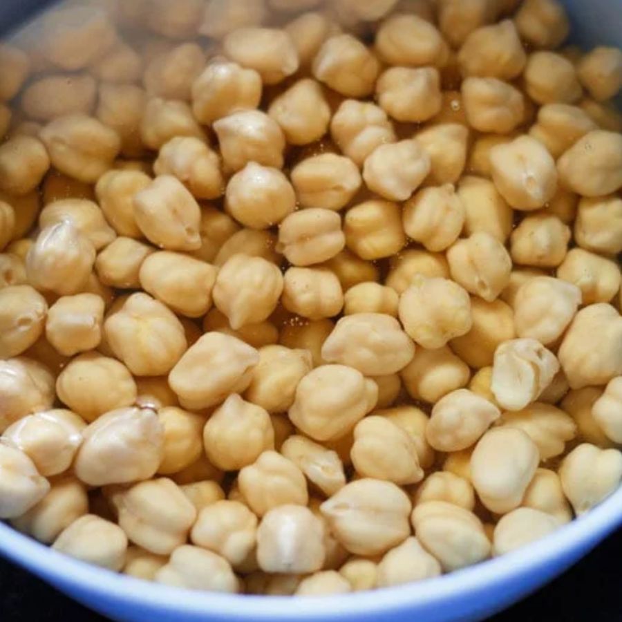 ৪। এ বার ডালনাটি বানানো যাক। এ ক্ষেত্রে এক দিন আগে ভিজিয়ে রাখতে হবে ছোলাগুলিকে। সকাল হতেই ভাল করে সেই জল ঝরিয়ে নিন। এ বার একটি পাত্রে ছোলাগুলিকে রেখে তাঁর সঙ্গে আদা ও লঙ্কা কুচি মিশিয়ে বেটে একটি মিশ্রণ তৈরি করুন। 