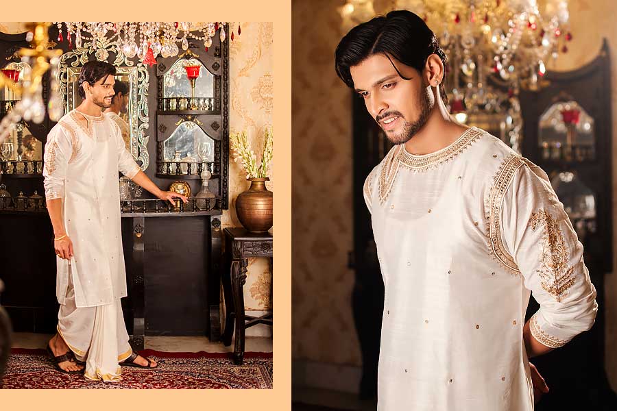 অষ্টমীর সকালে সাদা রঙের ধুতি-পাঞ্জাবি পরলে মন্দ হয় না। এ ক্ষেত্রে পছন্দের তালিকায় থাকতে পারে স্বর্ণসূত্র। ঘিয়ে রঙের সিল্কের পাঞ্জাবির উপর জারদৌসি নকশার কারুকাজ। এই পাঞ্জাবির আদলে রয়েছে খানিকটা উত্তমকুমারের ছায়া, সঙ্গে আবার রয়েছে আজকের বাবুমশাইদের পছন্দের ‘টাচ্’। নীচে চিরাচরিত কেরালা কটন ধুতি। আধুনিকতা আর সাবেকিয়ানা মিলেমিশে একাকার। 