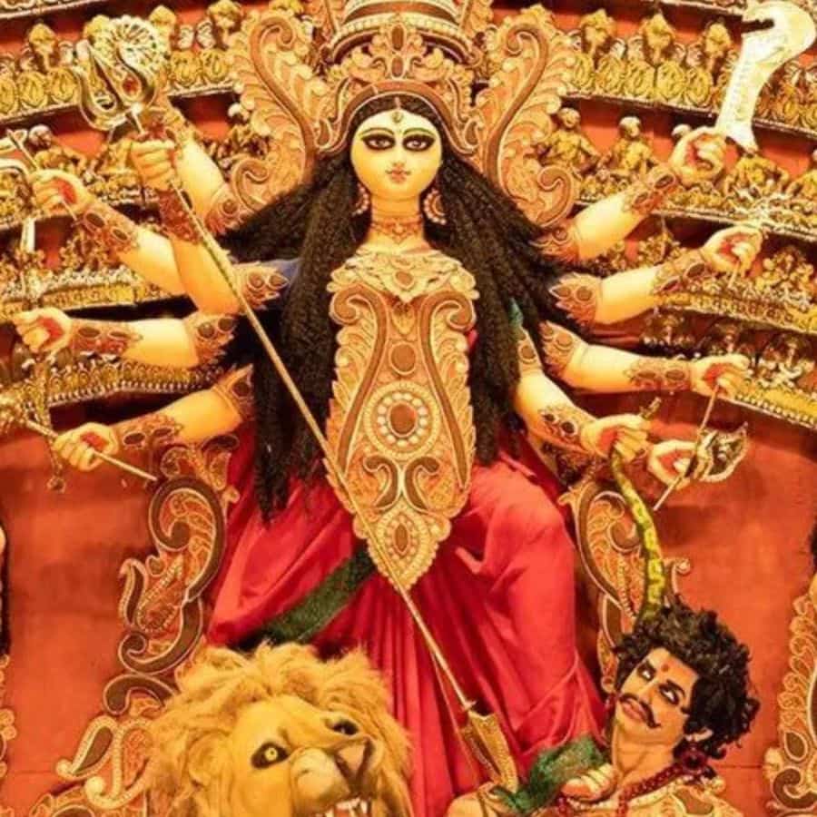 কুঠার ও বর্ম - কুঠার অসীম সাহসের প্রতীক। যার আঘাত প্রকাণ্ড বৃক্ষের কাণ্ডের মতো শক্তিশালী প্রতিবন্ধকতাকেও টুকরো টুকরো করে দেয়। আবার বর্ম হল চিন্তা শক্তি ও জ্ঞানের প্রতীক, যা অশুভ শক্তিকে প্রতিহত করতে সক্ষম। দেবীকে কুঠার ও বর্ম দিয়েছিলেন বিশ্বকর্মা। 