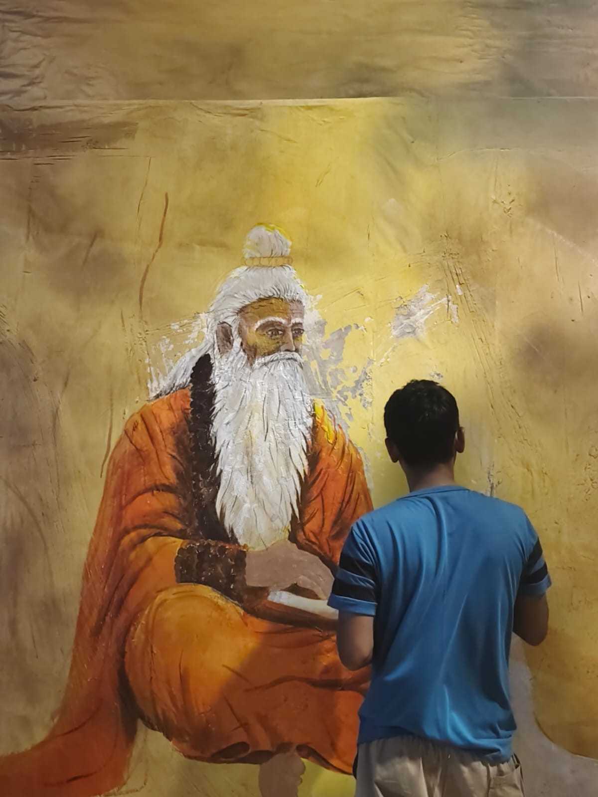 মণ্ডপের গায়ে সেই কাহিনি ফুটিয়ে তুলতে একের পর এক দেওয়াল চিত্র এঁকেছেন শিল্পীরা। 