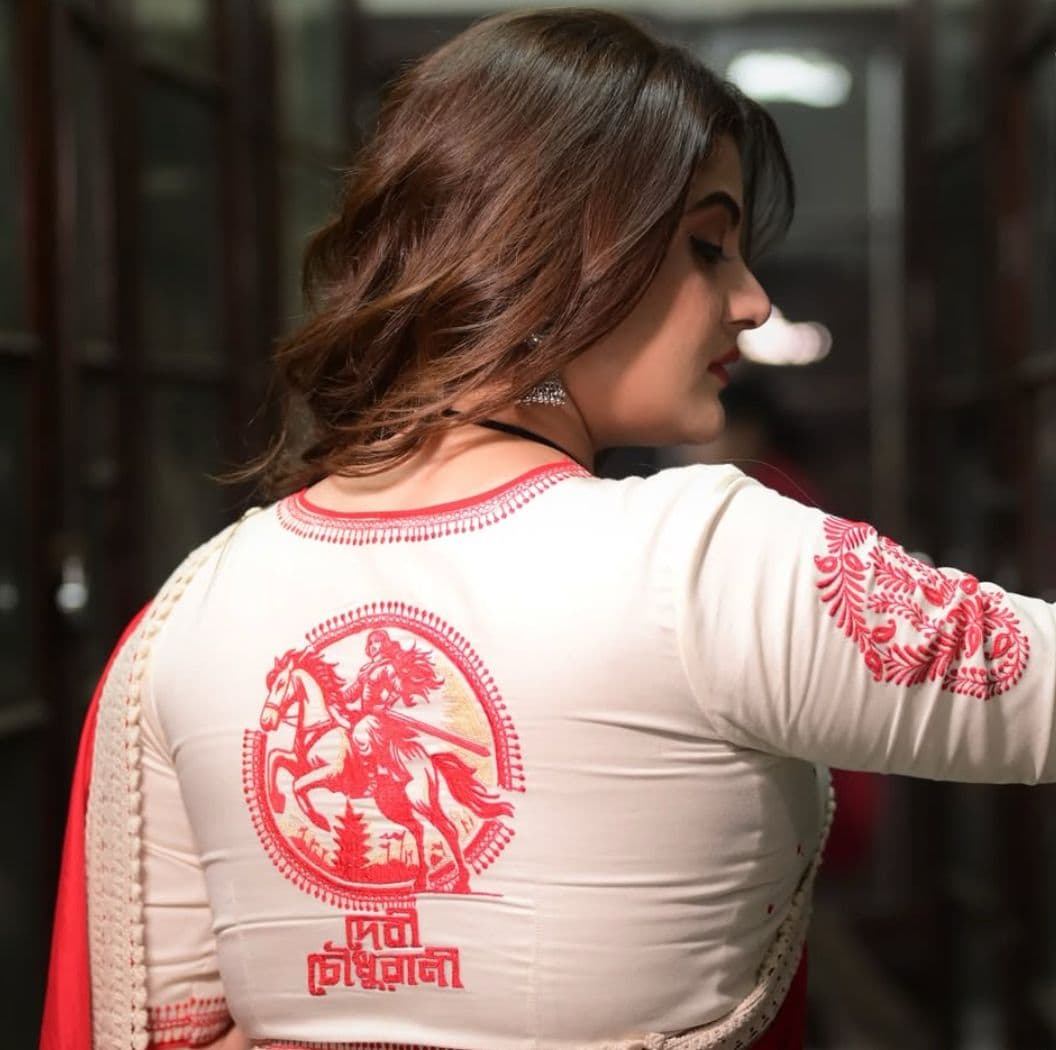 দশমীর দিনে শ্রাবন্তীর লাল পাড়ের সাদা ব্লাউজটি হতে পারে আপনার সাডের বাছাই। পিছন দিকে লাল ঘোড়ার প্রতিকৃতি, যা একইসঙ্গে ঐতিহ্যবাহী এবং আধুনিক।