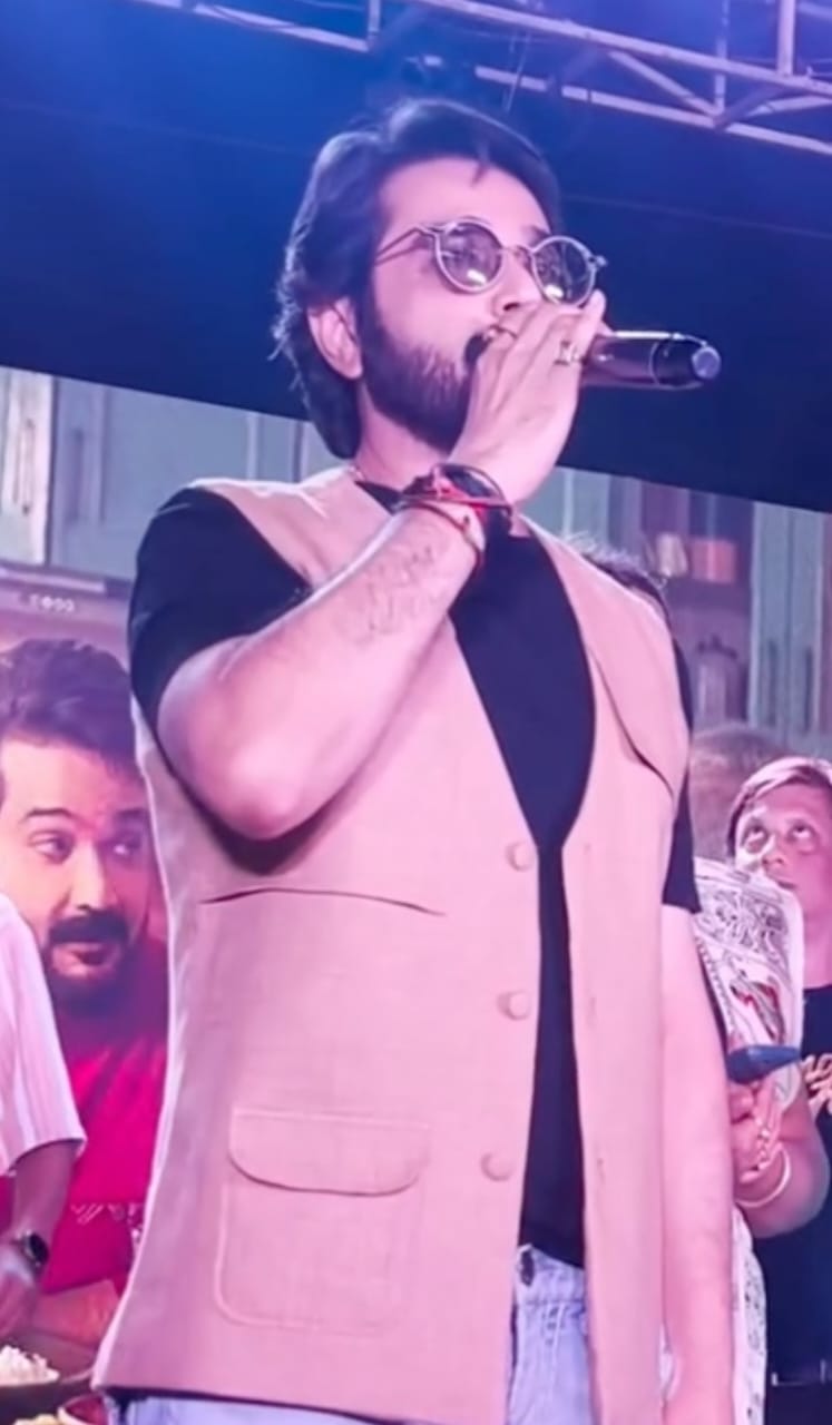 কখনও মঞ্চে পরেছেন কালো টি-শার্টের ওপর হালকা বাদামি বা বেইজ রঙের ভেস্ট, সঙ্গে মানানসই জিনস্‌। গোল ফ্রেমের সানগ্লাস আর হাতে ব্রেসলেট—দেখলে মনে হতে পারে, এই বুঝি এক আধুনিক রক্‌স্টার। 