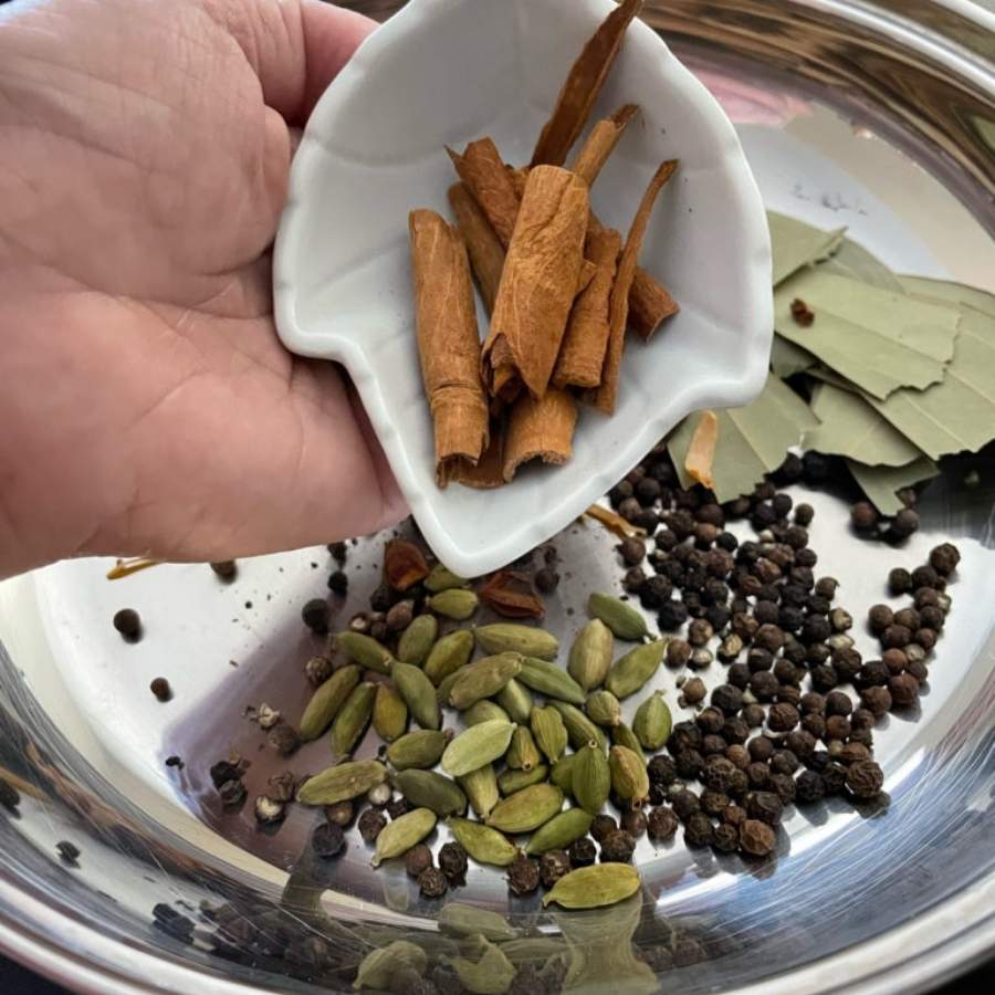 এ বার ওই পাত্রেই আরও ৩-৪ চামচ ঘি দিন। তাতে ফোড়ন হিসেবে দিন এলাচ, লবঙ্গ, তেজপাতা, শুকনো লঙ্কা, দারচিনি। সঙ্গে দিন অল্প জিরে, আধ চামচ গোটা সর্ষে, এক চিমটে হিং এবং এক চামচ গোলমরিচ। যোগ করুন আদা-লঙ্কার পেস্ট। ভাল করে নেড়ে নিন এ বার। 