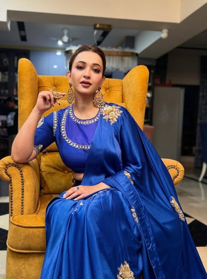 কৌশানী মুখোপাধ্যায় চতুর্থীর দিন একটি নীল সিল্ক শাড়িতে ধরা দিয়েছিলেন। সঙ্গে ছিল নীল তবে অন্য শেডের একটি কাজ করা ব্লাউজ়। 