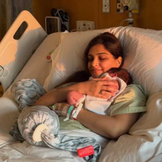 হাসপাতালের বিছানায় সদ্যোজাতকে কোলে নিয়ে সোনম। 