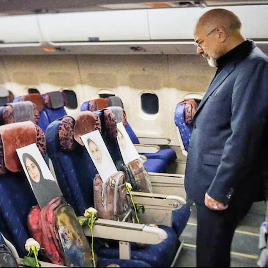 মার্কিন হামলায় হত ইরানের স্কুলপড়ুয়াদের ছবি এবং ব্যাগের সামনে স্পিকার মহম্মদ বাঘের গালিবাফ। ছবি: সংগৃহীত।