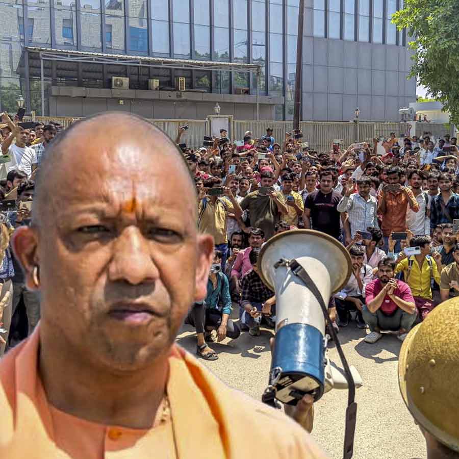 বিক্ষোভকারী শ্রমিকদের সঙ্গে কথা বলছে পুলিশ। অশান্তি সৃষ্টিকারীদের বিরুদ্ধে ব্যবস্থার নির্দেশ মুখ্যমন্ত্রী যোগী আদিত্যনাথের (ইনসেটে)।