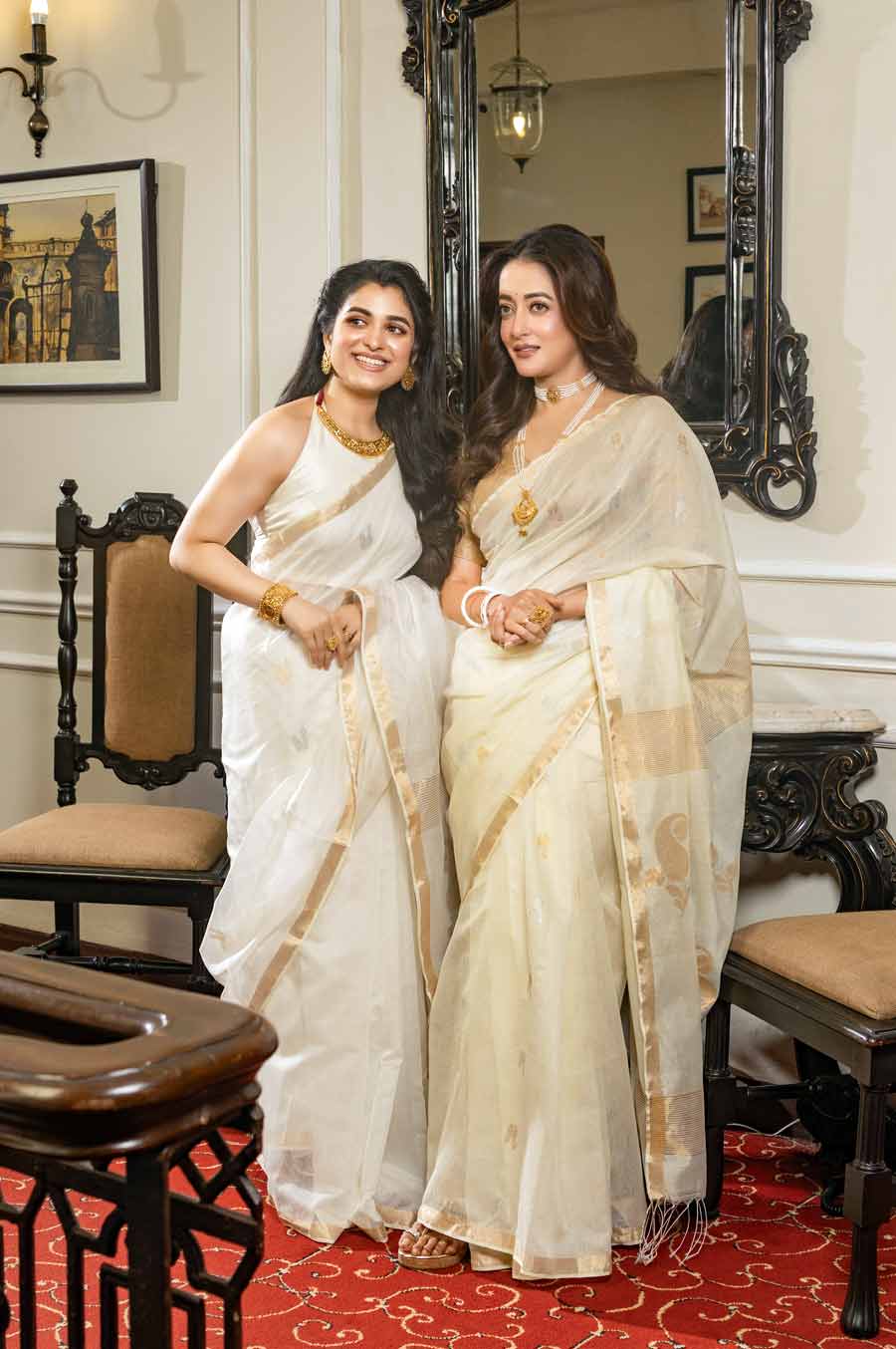 দুই নায়িকার দুই শাড়ির রং ঠিক সাদা নয়, বরং সেগুলি আইভরি রঙের। হ্যান্ডলুম মসলিন শাড়ির উপর সোনালি এবং রুপোলি সুতোর কাজ করা। শ্যামৌপ্তিকে হল্টার নেক ব্লাউজ় দিয়ে সাজিয়েছেন অনুপম। রাইমাকে পরিয়েছেন হাতাযুক্ত জামেওয়ার গোল্ডেন ব্লাউজ়। আইভরি এবং সোনালি রঙের মেলবন্ধনের কথা মাথায় রেখে নকশা করা হার, হাতে গিনিচুড়, কানে বড় ঝোলা পাশা দিয়ে সাজানো হয়েছে ছোট বোনকে। রাইমার পরনে ছিল মুক্তোর চোকার এবং মুক্তোরই সীতাহার। হাতে শাঁখাবাঁধানো বালা। দু’জনের চুলেই আনা হয়েছে সফ্‌ট কার্ল। বৈশাখের প্রথম দিন সকালে এমন সাজ সাজলে চড়াও মনে হবে না, আবার একেবারে সাদামাঠাও লাগবে না।