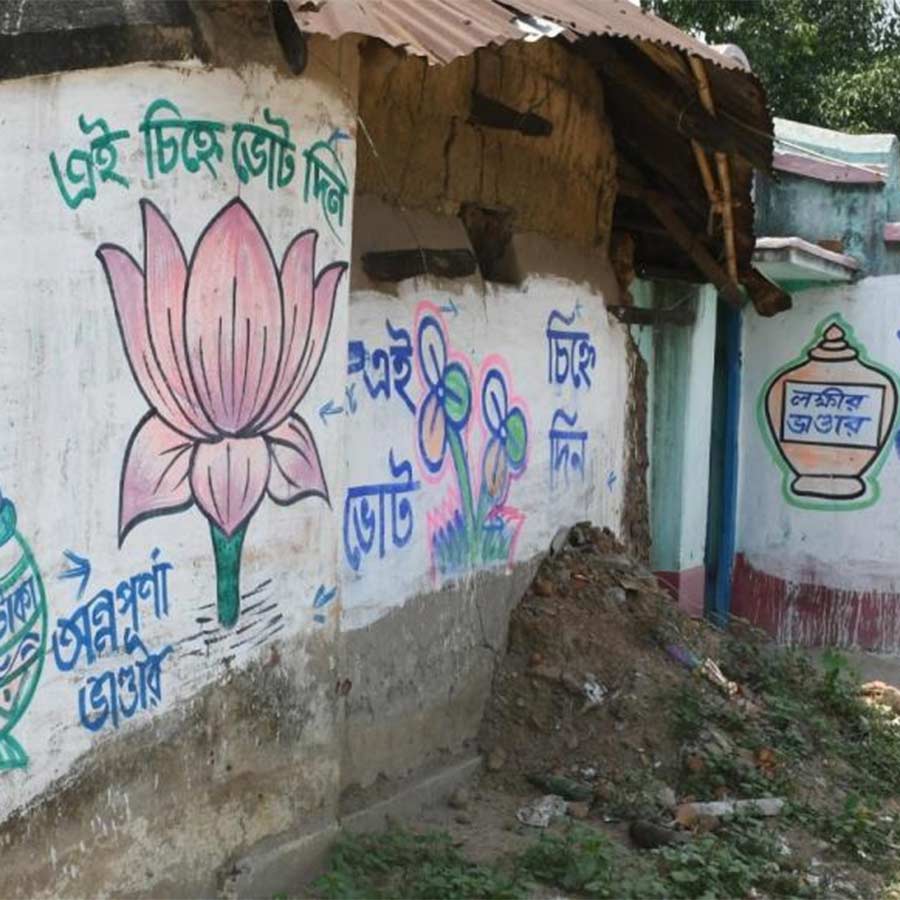 ভাতার লড়াই এক দেওয়ালে। এক দিকে শাসকদলের লক্ষ্মীর ভান্ডার, অন্য দিকে বিজেপির প্রস্তাবিত অন্নপূর্ণা ভান্ডার। দুবরাজপুরের চণ্ডীপুর গ্রামে।