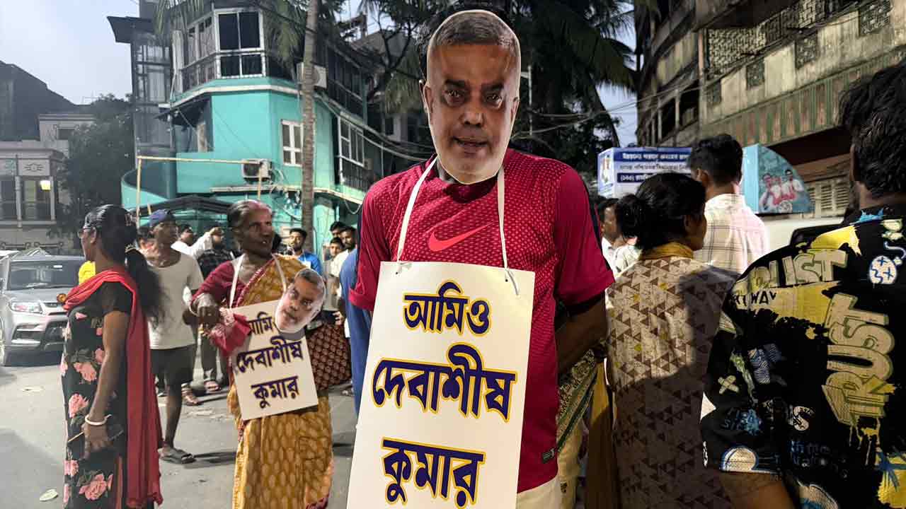 ‘আমি দেবাশিস কুমার’ পোস্টার গলায় ঝুলিয়ে তৃণমূল নেতার মনোহরপুকুর রোডের বাড়ির সামনে দাঁড়িয়ে তৃণমূল কর্মী।