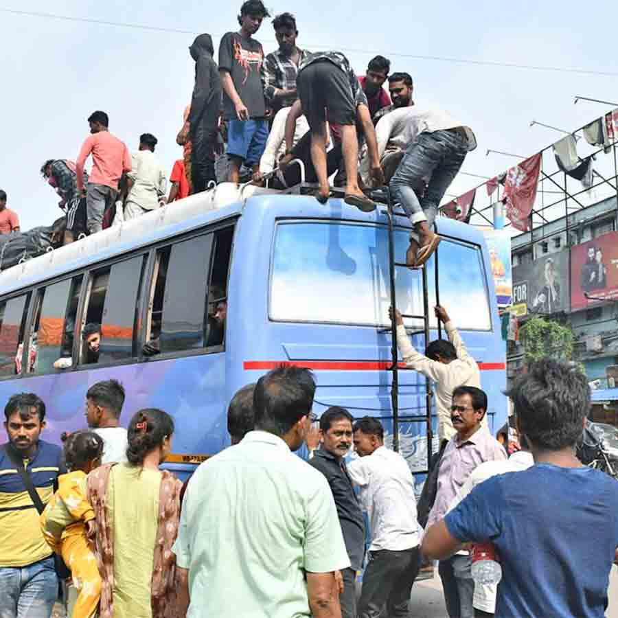 বাসের ছাদে চেপেও ভোট দেওয়ার জন্য ফিরছেন পরিযায়ী শ্রমিকেরা। সোমবার বহরমপুরে বাসস্ট্যান্ডে।