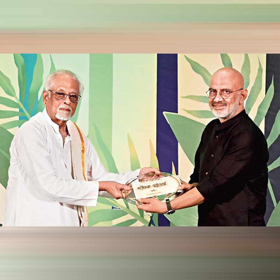 পরিমল ভট্টাচার্যের হাতে আনন্দ পুরস্কার তুলে দিচ্ছেন পার্থ ঘোষ। শনিবার।