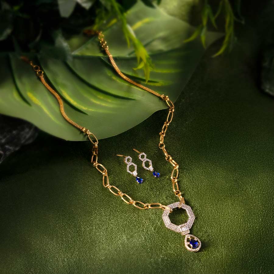 DGN-D000772055, DTGN-D000772056 - এই ১৪ ক্যারেট সোনার নেকলেসে ০.৯১ ক্যারেট হিরে বসানো আছে। জ্যামিতিক নকশার হিরে-খচিত পেনডেন্টের সঙ্গে গাঢ় নীল পাথর নেকলেসটিকে করে তুলেছে রাজকীয়। 