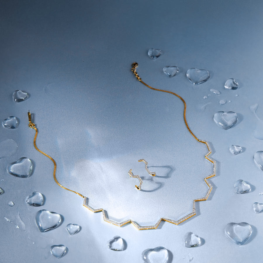 DGN-D000839548, DTGN-D000839549 - এই নেকলেসে ১.৪৩ ক্যারেট হিরে বসানো আছে, যা গলার রেখা বরাবর সুন্দর আকৃতি তৈরি করে এবং আপনার আভিজাত্যকে ফুটিয়ে তোলে। এর সঙ্গে রয়েছে ০.১২ ক্যারেট হিরে বসানো কানের দুল। পুরো সেটটি হালকা, অভিব্যক্তিপূর্ণ এবং  সহজেই মার্জিত এক সৌন্দর্য্য এনে দেয়।