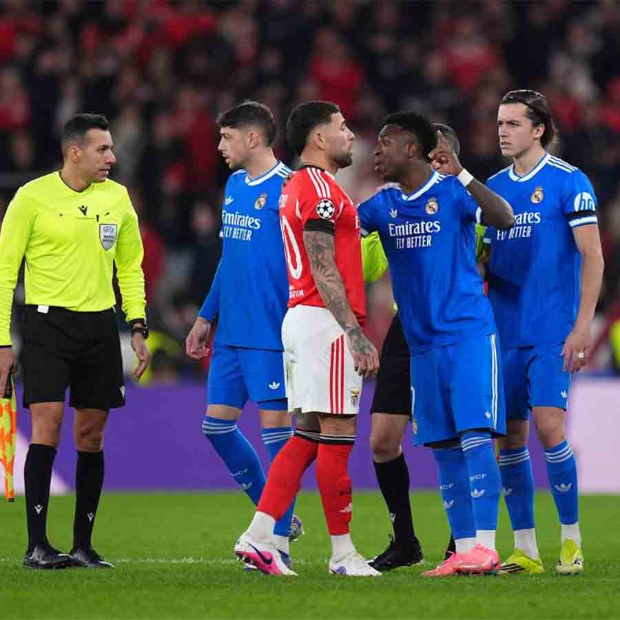 উত্তেজনা: রিয়াল তারকা ভিনিশিয়াসকে শান্ত করার চেষ্টায় বেনফিকা অধিনায়ক ওতামেন্দি। 