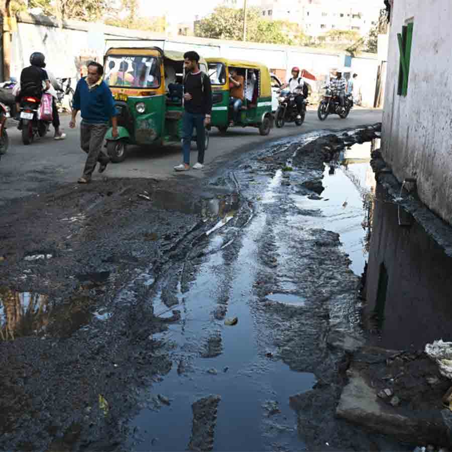 বেহাল: নিকাশির পাঁক, জল উপচে এসেছে রাস্তায়। তার মধ্যে দিয়ে কোনও মতে যাতায়াত স্থানীয় মানুষের। বুধবার, তিলজলা রোডে।